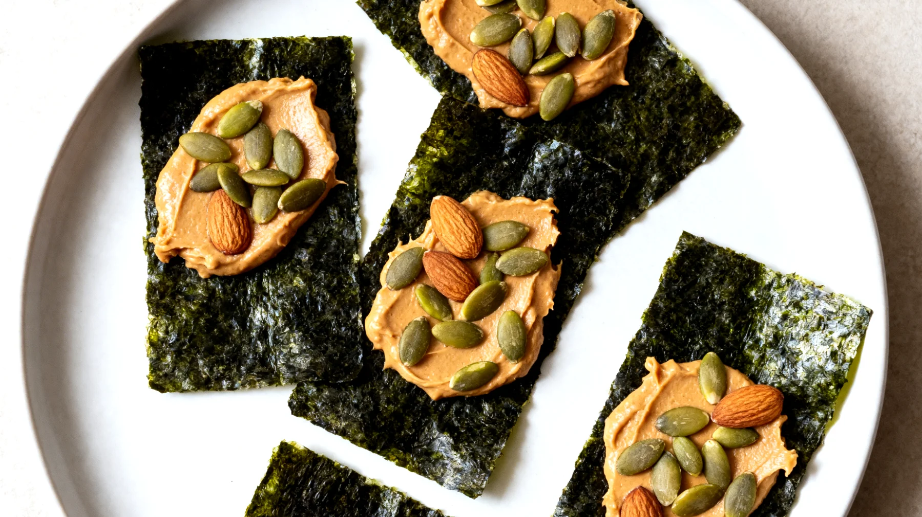 Nori-Algenblätter mit Mandelbutter und Kürbiskernen"